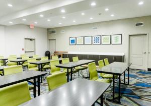 an empty classroom with tables and yellow chairs at Holiday Inn Express Hotel & Suites Greenville, an IHG Hotel in Greenville
