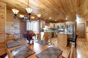 a kitchen with a wooden ceiling and a table with chairs at Bearfoot Lodge in Ellijay