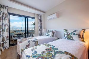 two beds in a hotel room with a balcony at Ece Marina Suit in Fethiye
