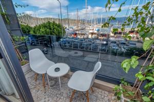 einen Balkon mit weißen Stühlen und Blick auf den Yachthafen in der Unterkunft Ece Marina Suit in Fethiye
