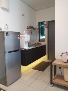 una cucina con frigorifero in acciaio inossidabile e lavandino di A29 Benoni Garden Suites a Papar