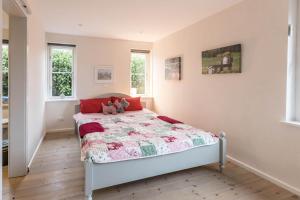 a bedroom with a bed with a quilt on it at Ferienhaus Mitteldeich in Hellschen-Heringsand-Unterschaar