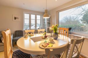 a dining room with a table and chairs and a window at Ferienhaus Mitteldeich in Hellschen-Heringsand-Unterschaar +22 photos