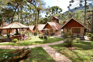 a house in the woods with a garden at Estalagem Monte Verde in Monte Verde