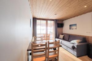 a living room with a couch and a table and chairs at Résidence Aiguille Lodge in Les Deux Alpes +16 photos