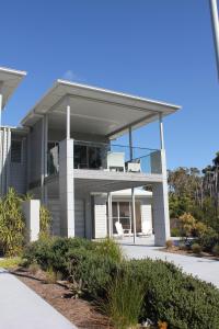 une grande maison avec deux chaises dans l'établissement Ayada Villa - Pet Friendly - 1 Min to Beach, à Culburra Beach