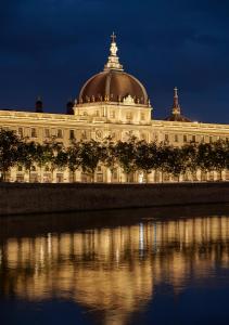 里昂的住宿－InterContinental Lyon - Hotel Dieu, an IHG Hotel，一座大型建筑,在晚上顶部设有圆顶