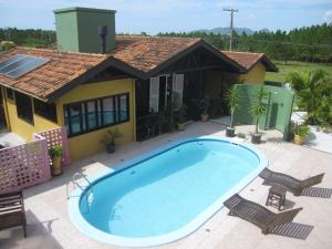 una piscina frente a una casa en Pousada Vento Sul, en Florianópolis