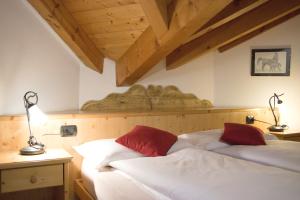 a bedroom with two beds and two lamps on a wall at Agritur Bontempelli in Pellizzano