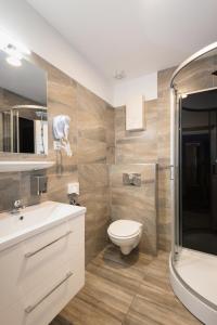 a bathroom with a toilet and a sink and a shower at City Apart Hotel in Düsseldorf