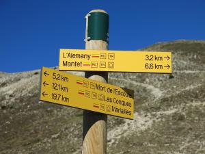 um sinal num poste de madeira com sinais nele em Can Batlló em Molló
