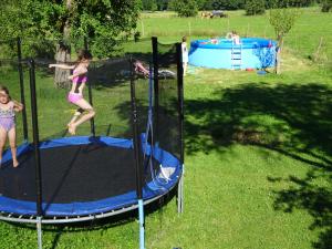 Due ragazze che saltano su un trampolino in un giardino di Sprenghof a Breitbrunn am Chiemsee