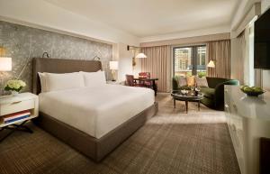 a bedroom with a large bed and a living room at Mandarin Oriental Boston in Boston