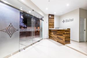 a glass pivot door in a lobby with a sign on the wall at Hotel Solec Piura in Piura