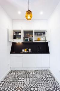 eine Küche mit weißen Schränken und einem schwarz-weißen Fliesenboden in der Unterkunft Home2Book El Faro de La Laguna, terrace & wifi in La Laguna