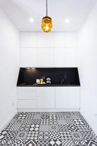 a kitchen with white cabinets and a black and white tile floor at Home2Book El Faro de La Laguna, terrace & wifi in Las Lagunas