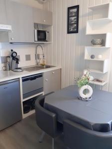 a small kitchen with a blue table and chairs at Studio LE COL DU TOURMALET 2-4 pers linge parking wifi in Barèges