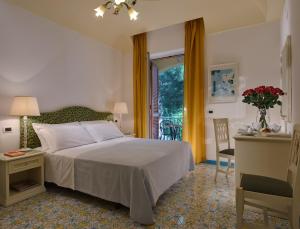 a bedroom with a bed, a dresser and a window at Hotel San Lorenzo Thermal Spa in Ischia
