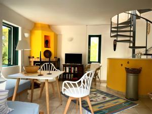 a living room with a table and chairs at Steinturm mit Dach-Terrasse zwischen Fluß, Meer und Gebirge- Spiti Pirgos in Paralía Sergoúlas