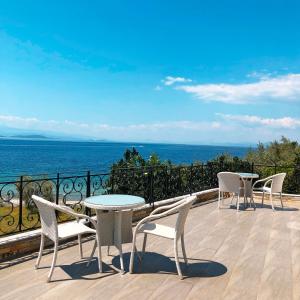 a patio with a table and chairs and the ocean at Lefkothea Studios in Chorto