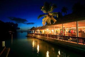 un edificio junto a un cuerpo de agua por la noche en Marigot Beach Club & Dive Resort, en Bahía Marigot