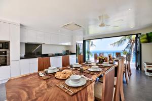 a kitchen and dining room with a large wooden table at Villa The Spot Koh Samui in Chaweng Noi Beach
