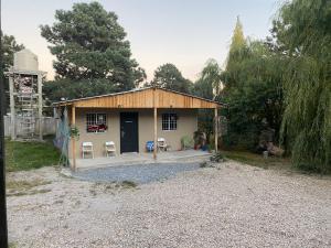 a small house with two chairs and a porch at Cabaña el Pino 1 in Creel