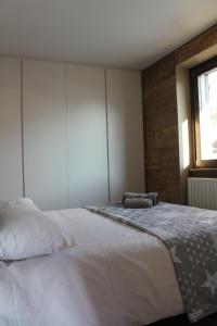a bedroom with a large white bed with a window at Casa Coltura in Bormio