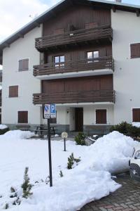 a building with a sign in the snow at Casa Coltura in Bormio