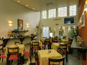 Hotel Elevado في بورتو أليغري: مطعم به طاولات وكراسي في غرفة +36 صورة