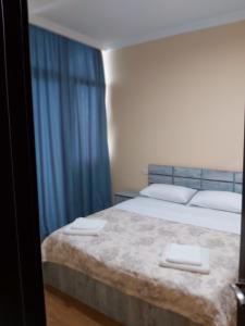 a bedroom with a bed with two towels on it at 2-х комнатная квартира на берегу моря Колхида in Batumi