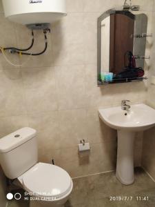 a bathroom with a toilet and a sink at 2-х комнатная квартира на берегу моря Колхида in Batumi +61 photos
