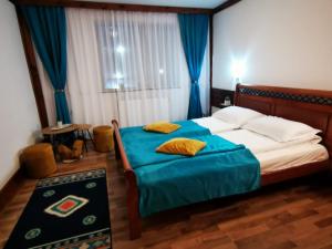 a bedroom with a bed with blue sheets and a blue blanket at Vila Romanitza in Dărmăneşti