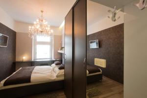 1 dormitorio con cama y lámpara de araña en Piu Trendy Rooms, en Zagreb
