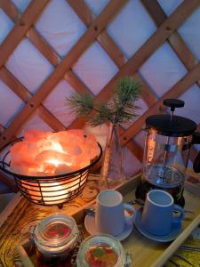 stół z kubkami i miską jedzenia i latarnią w obiekcie Valhalla Yurts Odin w mieście Selfoss