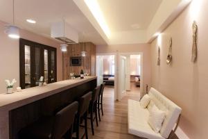 a kitchen with a long bar with chairs at Piu Trendy Rooms in Zagreb