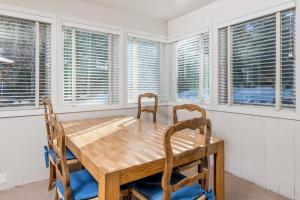 a dining room with a wooden table and chairs and windows at Prospector 204 in Ketchum