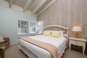 a bedroom with a white bed and two windows at Prospector 204 in Ketchum