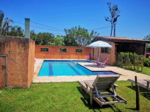 a swimming pool in the yard of a house at Chalés Ki Aconchego -Condominio Morada da Praia - Boracéia in Boracéia