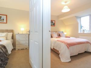a bedroom with two beds and a window at The Seventeen in Bourton on the Water