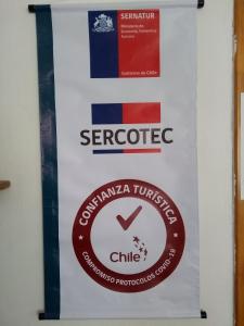 una pancarta colgada en una pared con la bandera de Serbia en Hostal Maria Casa en La Serena