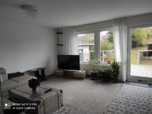 a living room with a couch and a flat screen tv at Waldhus in Ueckeritz