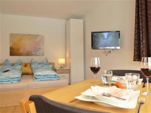 a room with a table with wine glasses and a bed at Cozy mountain view apartment with terrace and garden in Innsbruck