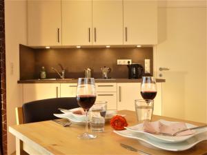 a wooden table with two glasses of wine on it at Cozy mountain view apartment with terrace and garden in Innsbruck