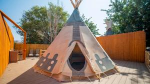 a teepee tent with a ladder on a deck at OK RV Park Glamping Tipi OK54 in Moab