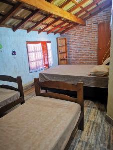 a room with two beds and two benches in it at Chalés Ki Aconchego -Condominio Morada da Praia - Boracéia in Boracéia +54 photos