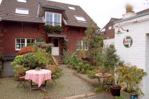 uma casa com uma mesa e cadeiras em frente em Haus Rothenstein, ruhige FeWo, ca. 10 min. zu Messe und Flughafen em Meerbusch