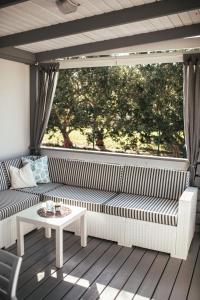 eine Veranda mit einem Sofa, einem Tisch und einem Fenster in der Unterkunft Rasin Mobile Homes in Pakoštane