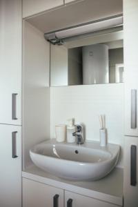 a bathroom with a sink and a mirror at Rasin Mobile Homes in Pakoštane