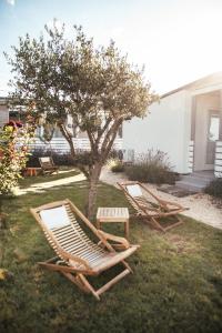 two lounge chairs and a tree in a yard at Rasin Mobile Homes in Pakoštane